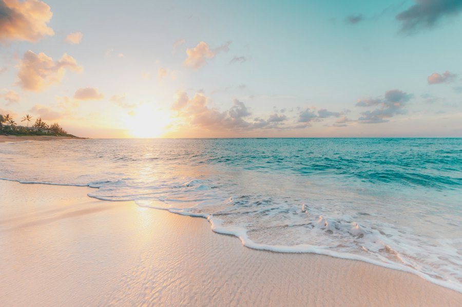 Gentle waves on a golden Caribbean beach at sunrise