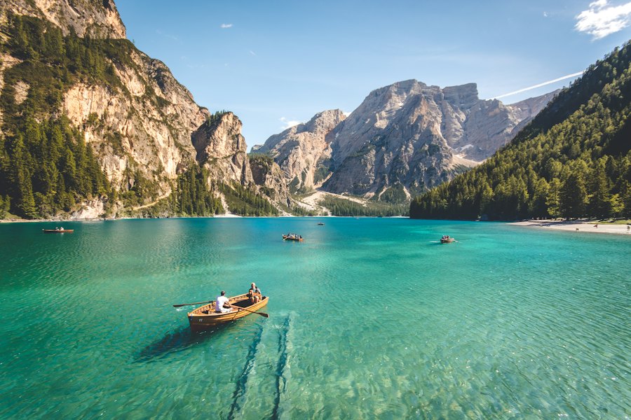 Turquoise alpine lake with a small rowing boat, Dolomites, Italy