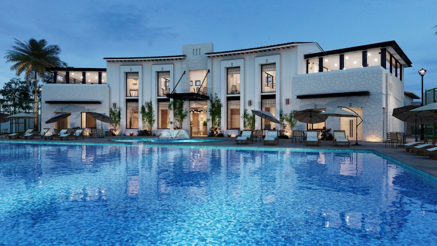 White resort building with a long blue swimming pool at dusk